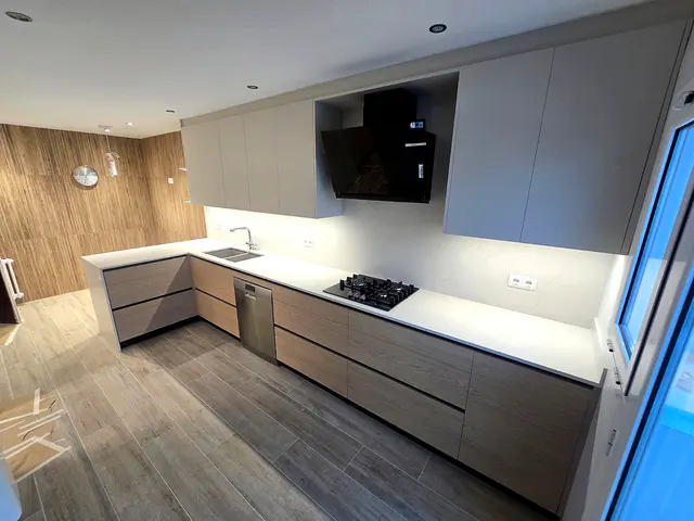 Cocina en U en madera y gris claro con pared revestida de lamas en tono madera